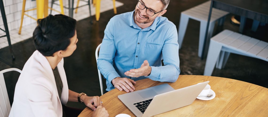 Shot of a man and woman having a discussion during a meeting in a coffee shop