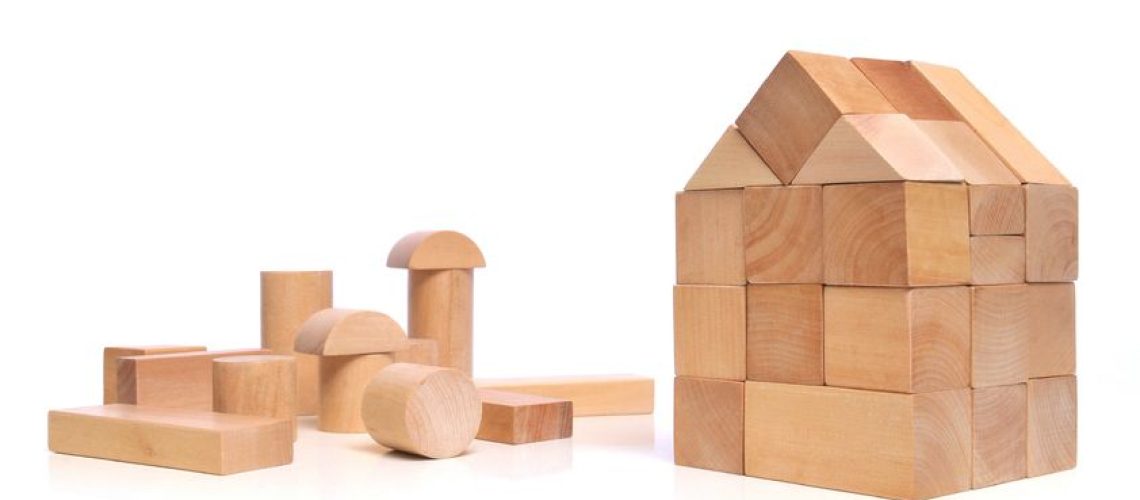 13425644 - little town house of natural colored toy blocks on white background